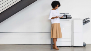 woman standing by a large printer