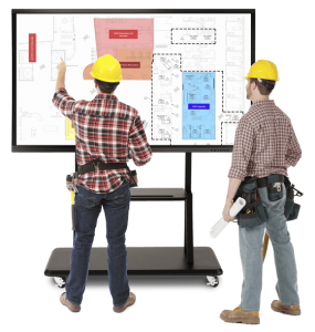 construction workers in hard hats using a gift smart screen to view construction plans